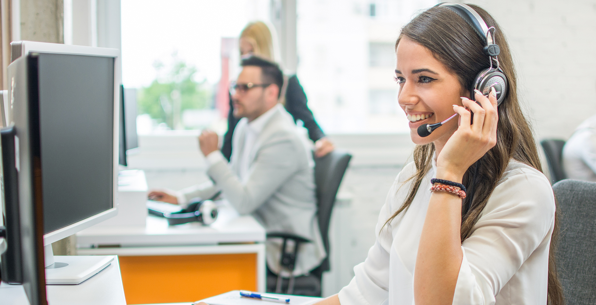 Young smiling operator woman agent with headsets working in a ca